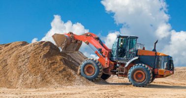 istockphoto-1173574280-612×612 Backhoe loader or bulldozer - excavator with clipping path on a background with blue sky and clouds. work on construction site or sand pit.